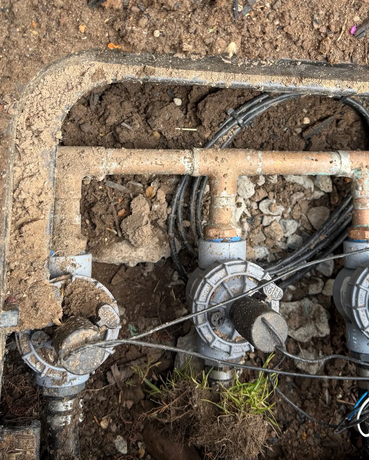 Underground sprinkler valve manifold and irrigation piping