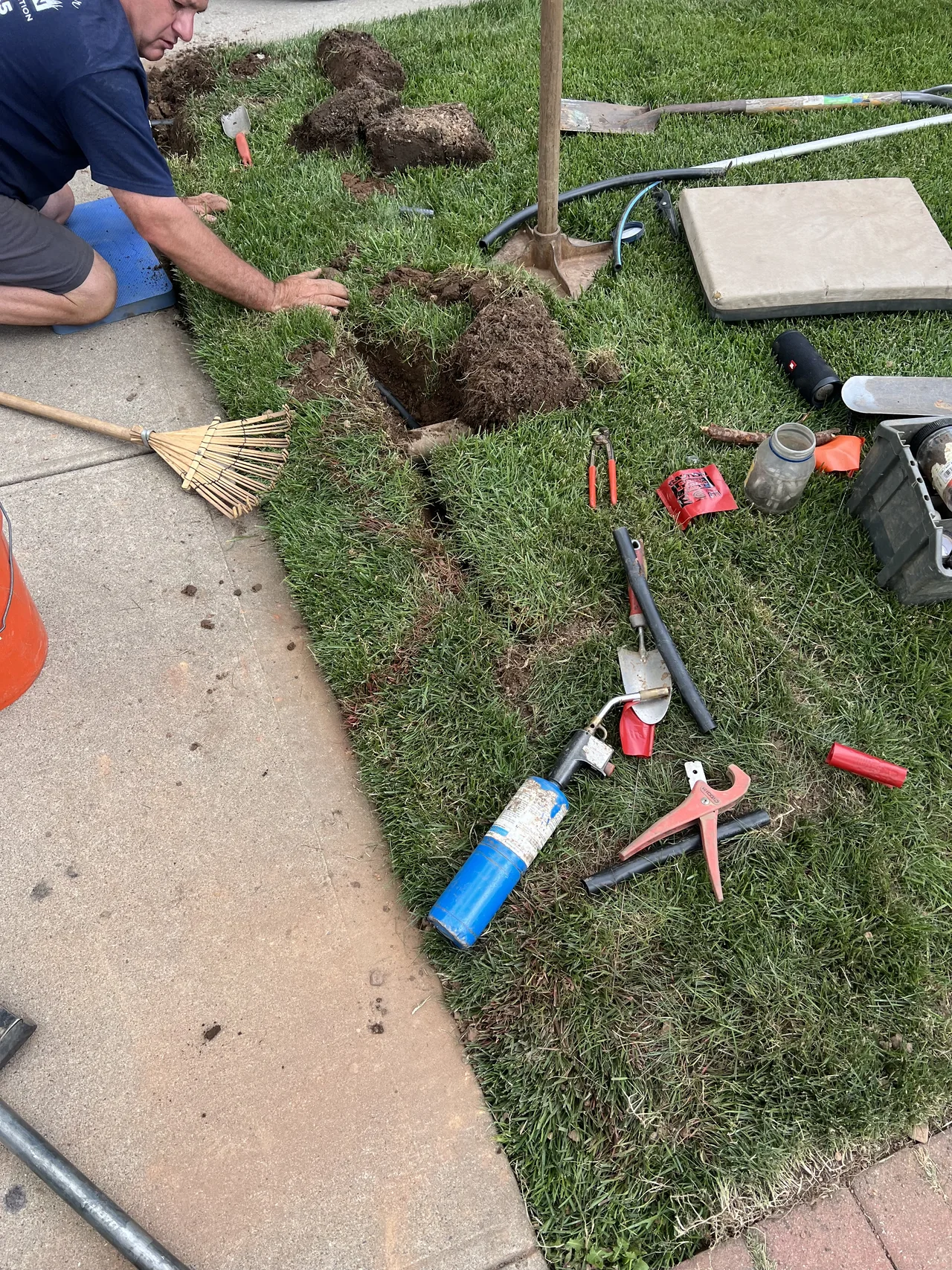 Sprinkler pipe and trench work beside a sidewalk