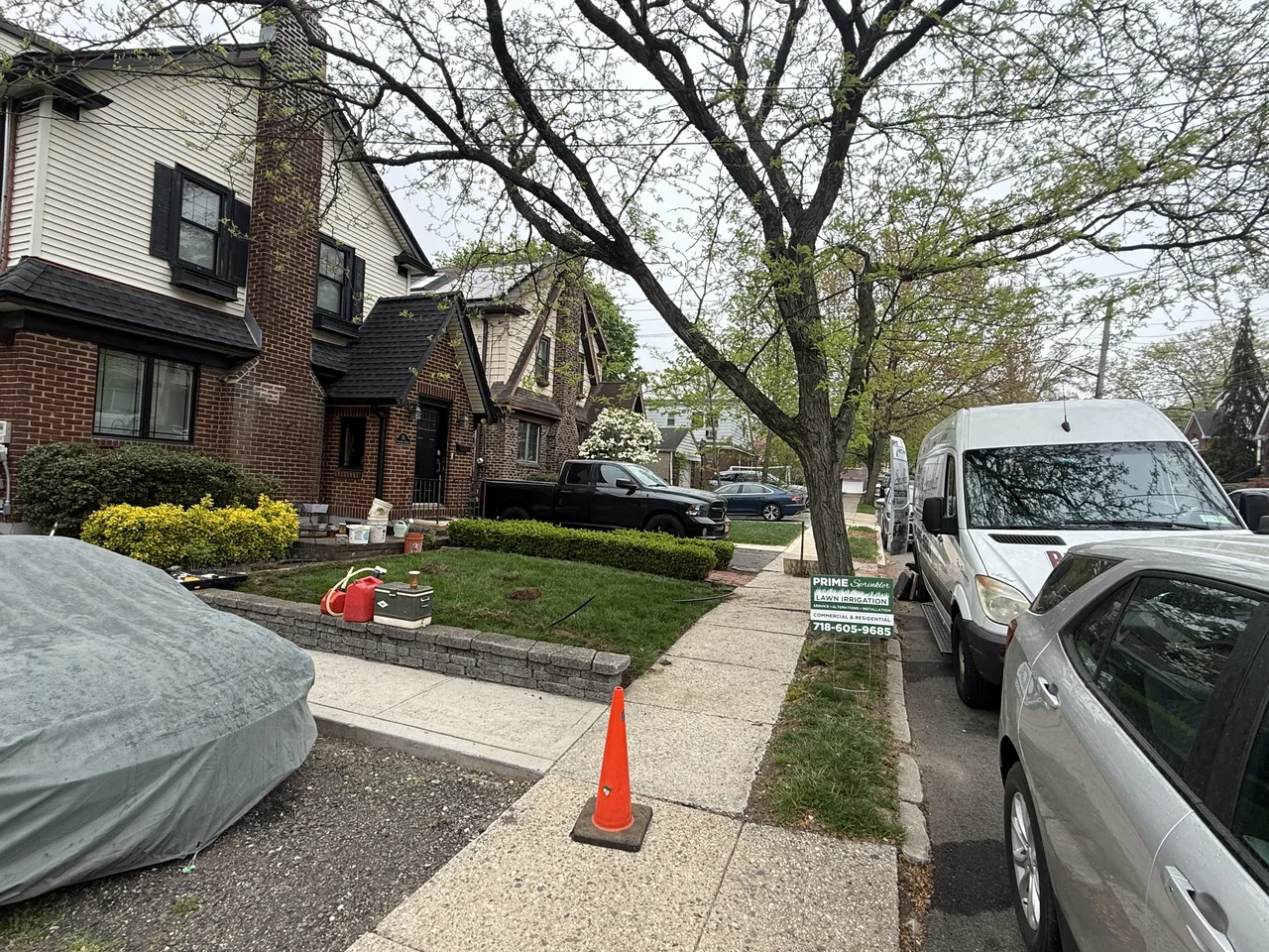 Technician working beside a sidewalk during sprinkler installation