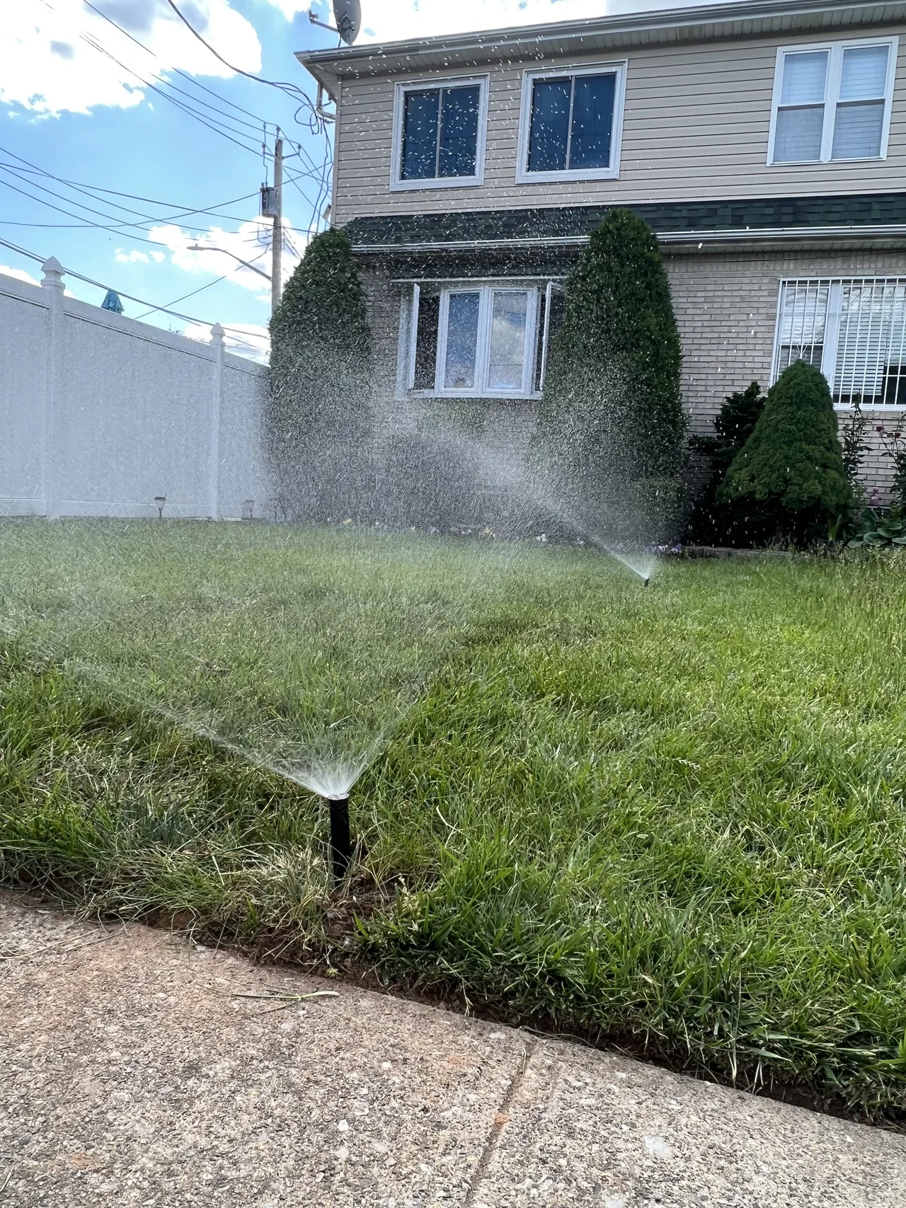 Sprinkler heads running across a green residential lawn