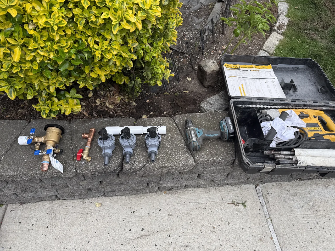 Sprinkler installation tools, pipe, and trench work viewed from above