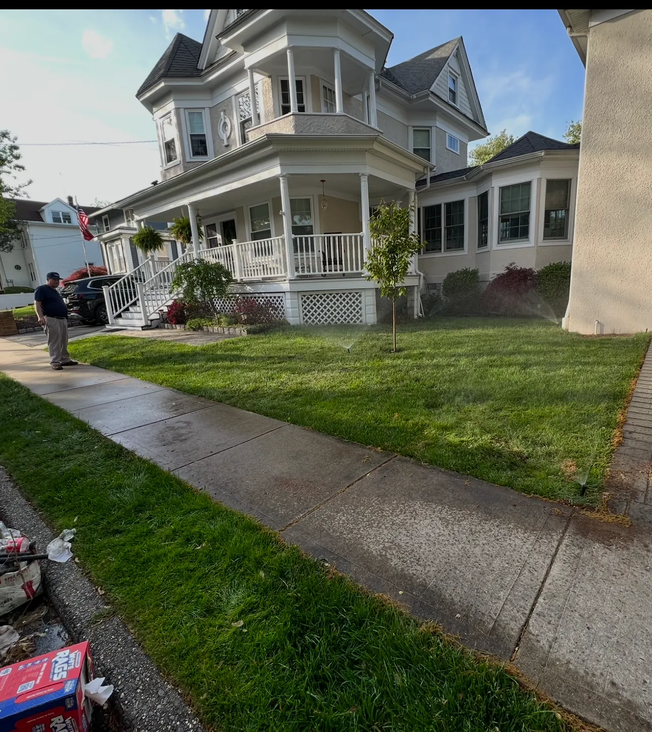 Wide Staten Island lawn with sprinklers running near the sidewalk